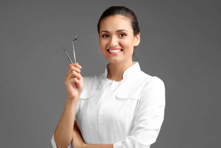 dentist smiling with dental tools