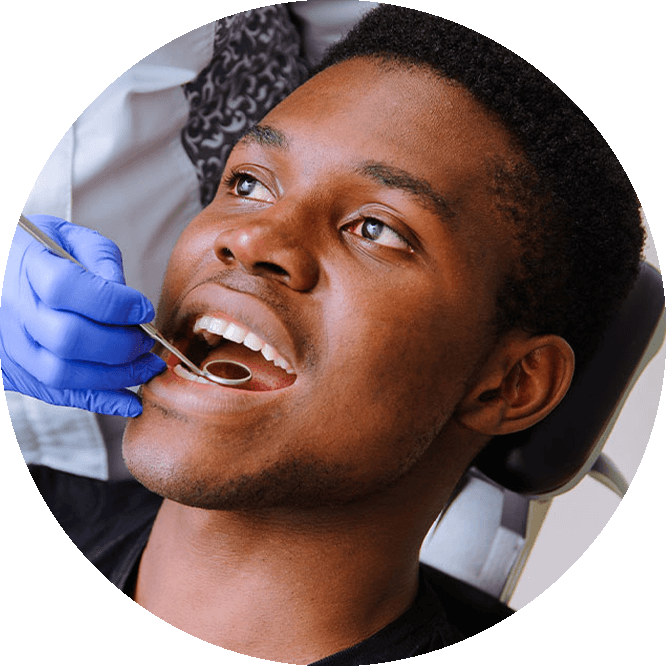 A man is in the dental chair getting a dental procedure.