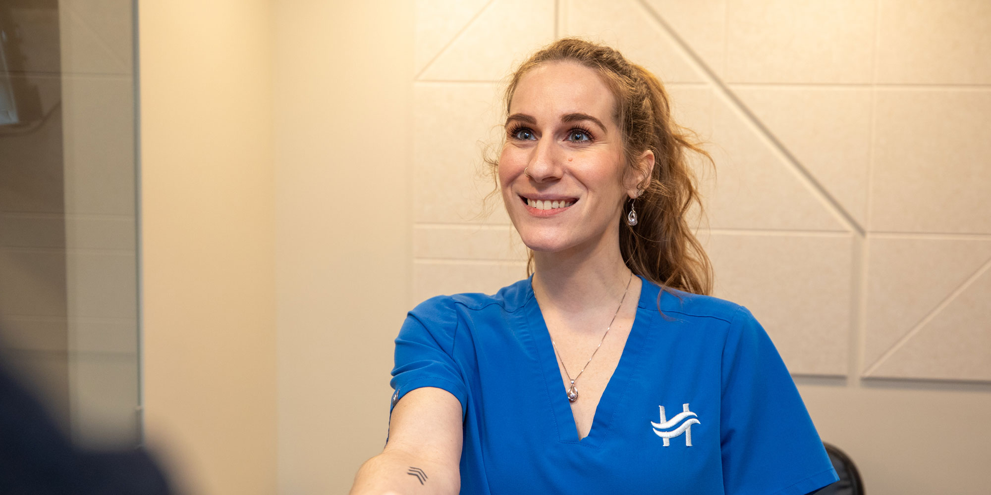 team member shaking hands with patient at the front desk within the dental center