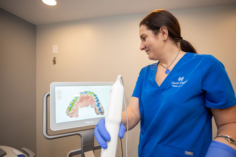 staff member examining patient with dental device within the dental center