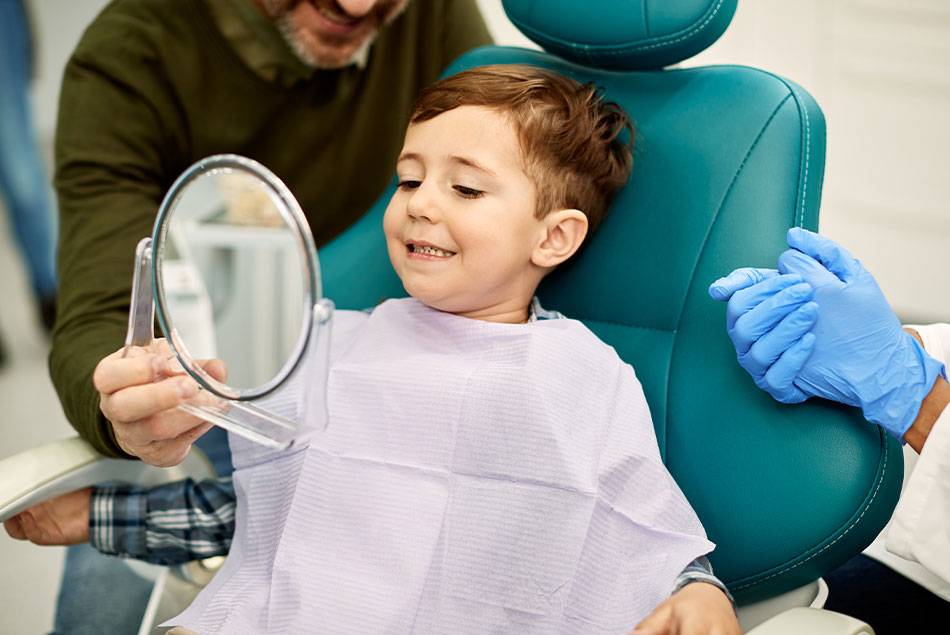 child patient smiling brightly after their dental treatment