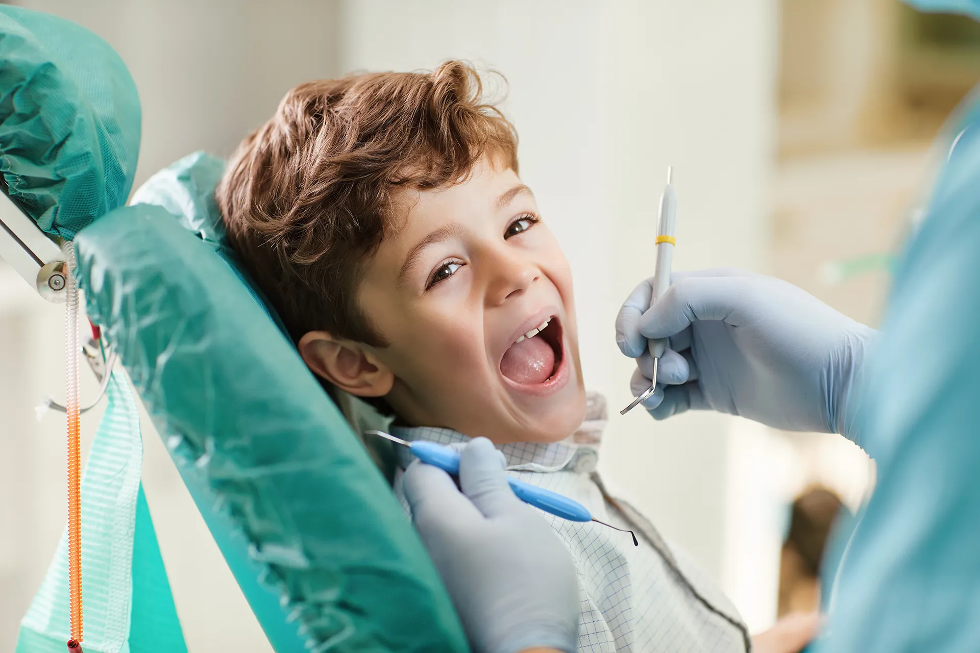 Child in dental chair excited for a check-up, demonstrating pediatric dental care.