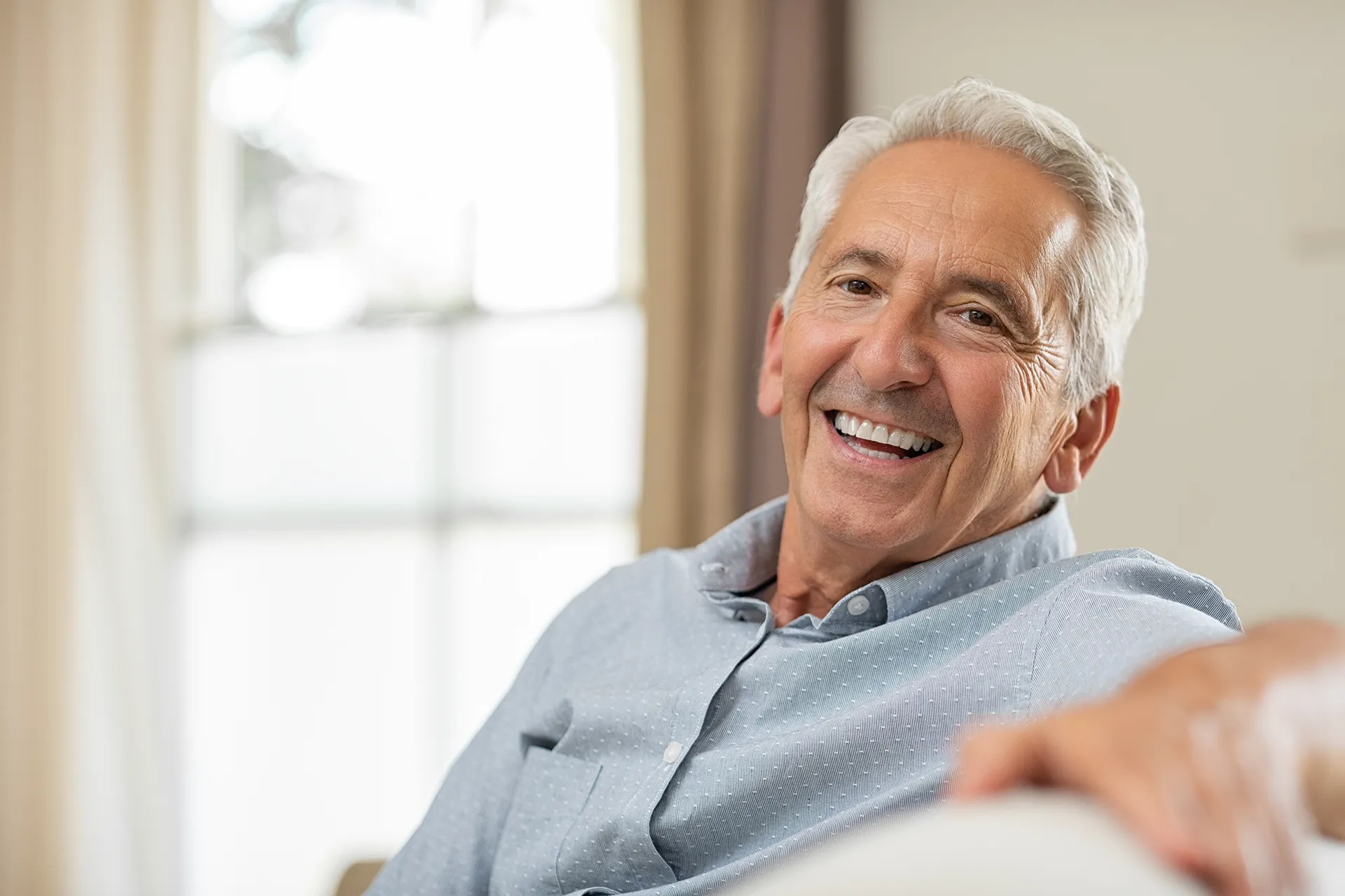 Senior man smiling at home.