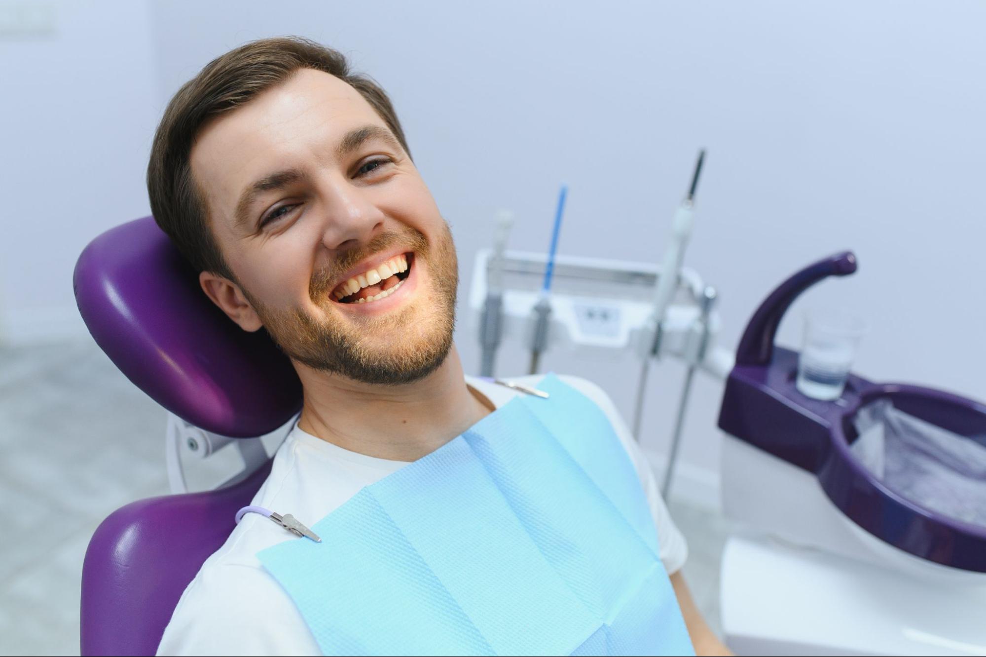 Man in a dental exam chair smiling.
