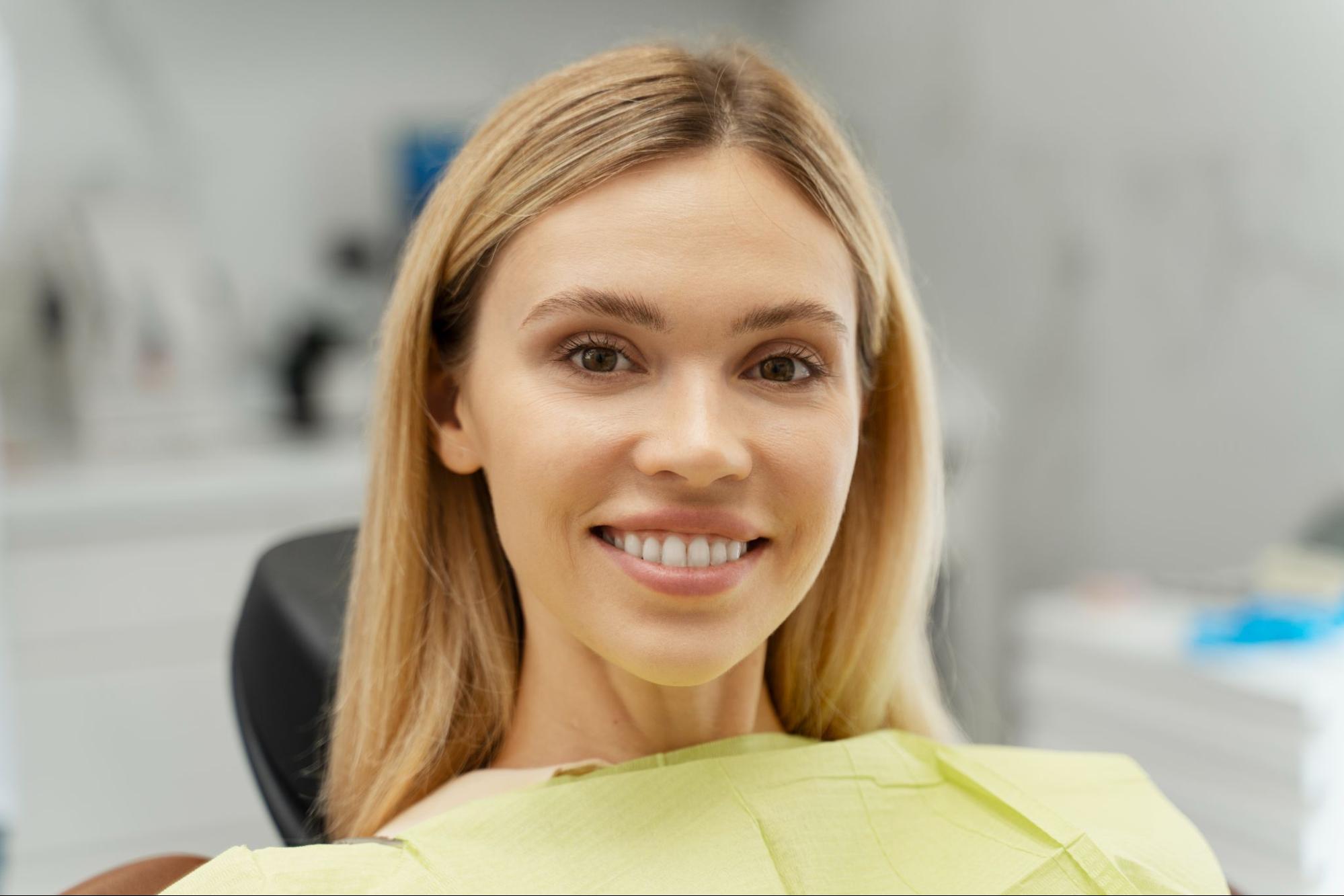 Woman with a white smile in an exam chair.