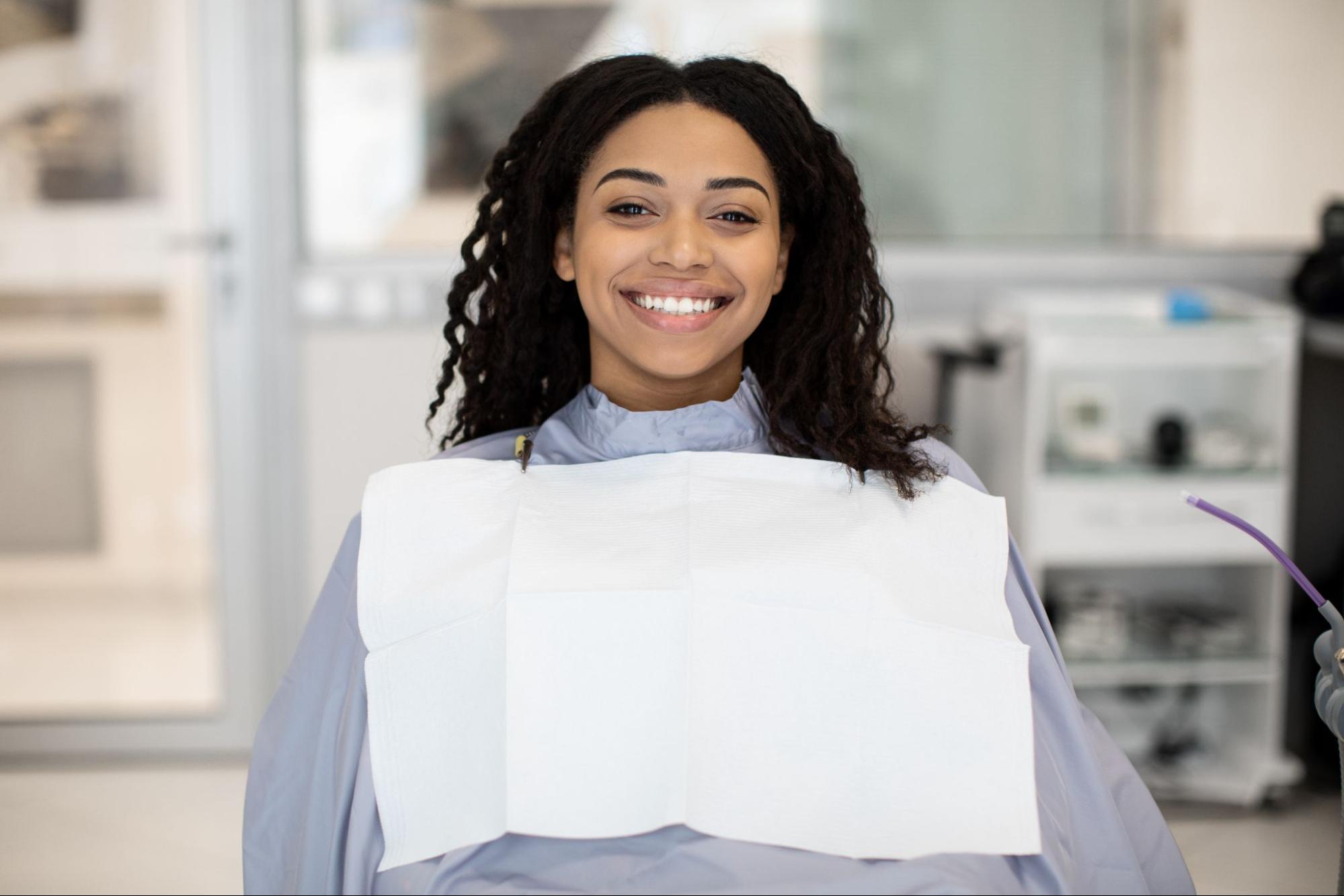 Woman smiling in a dental exam chair. 