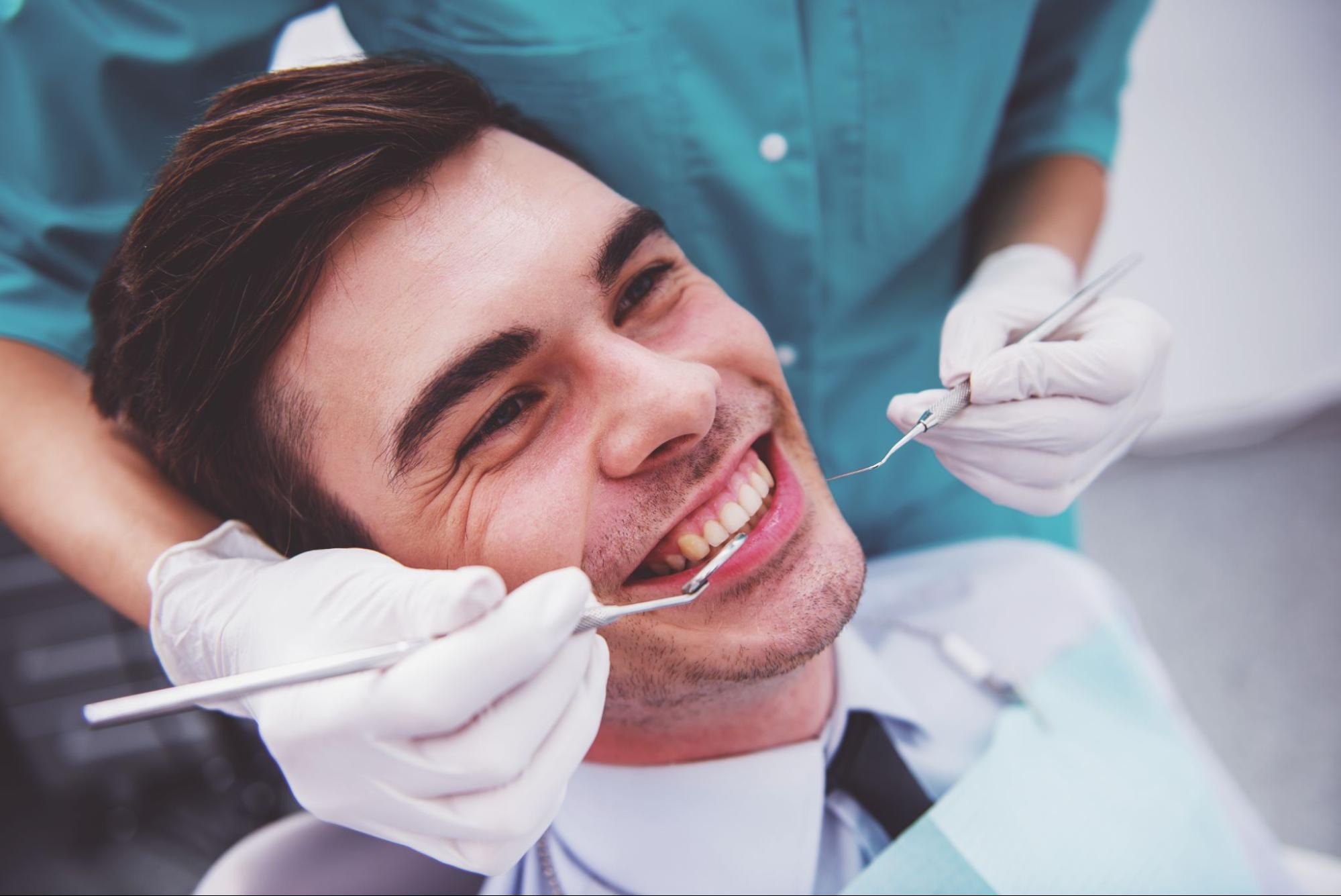 Man in an exam chair smiling. 
