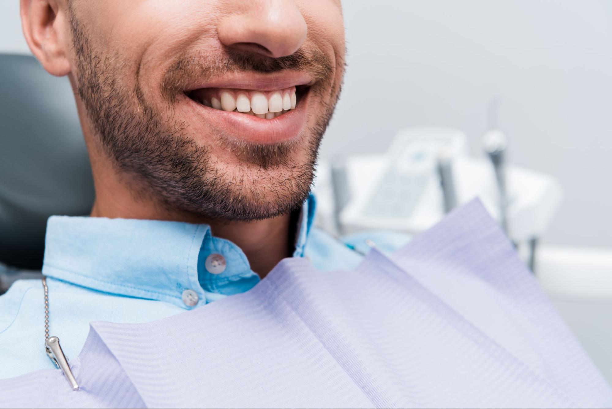 Man with a white smile in a dental exam chair. 