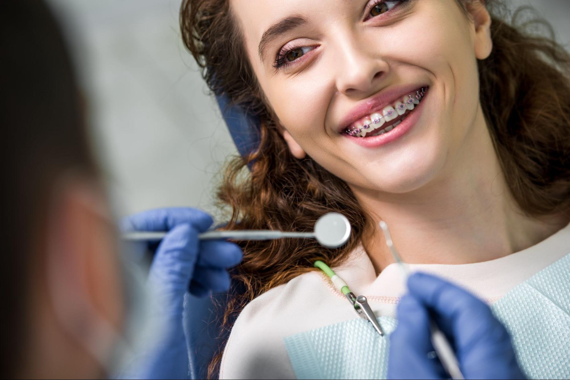 Girl with braces smiling in an exam chair. 