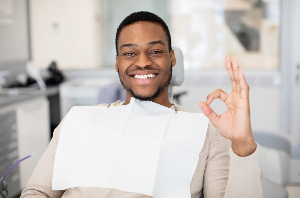Dental professional consulting a patient with teeth cleaning tools visible