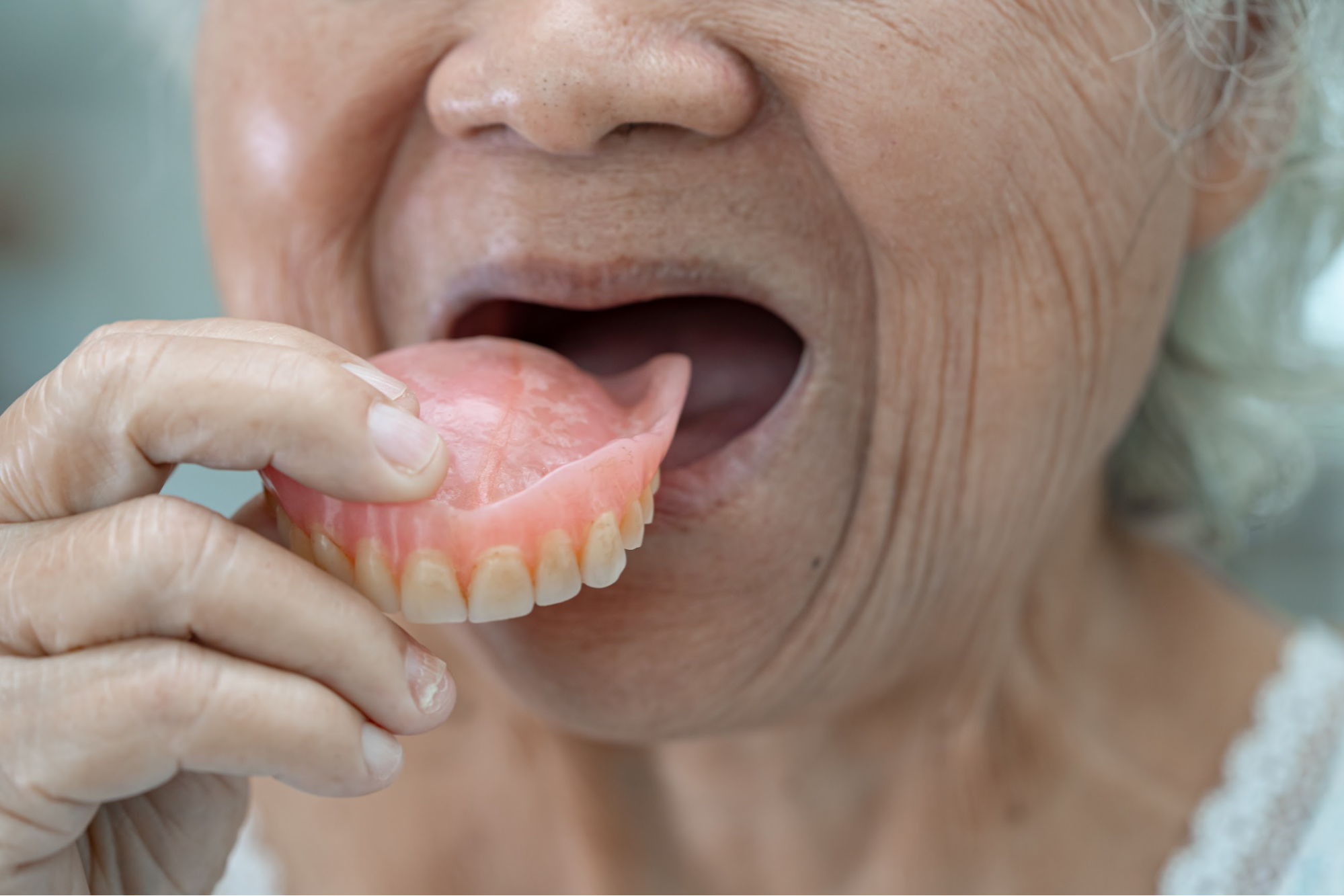 A woman inserting her dentures.