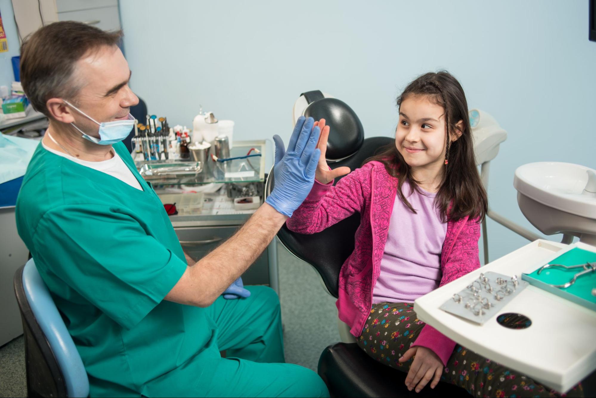 Girl giving a dentist a high-five. 
