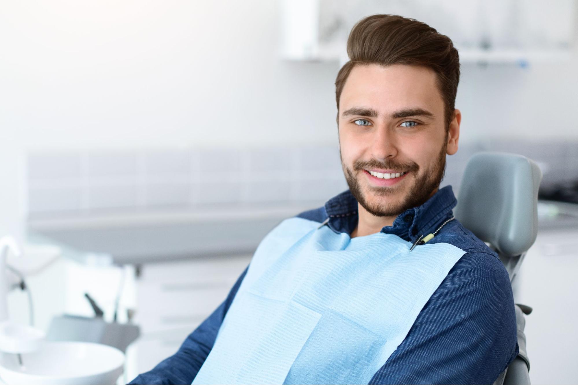 Man smiling in a dental exam chair. 