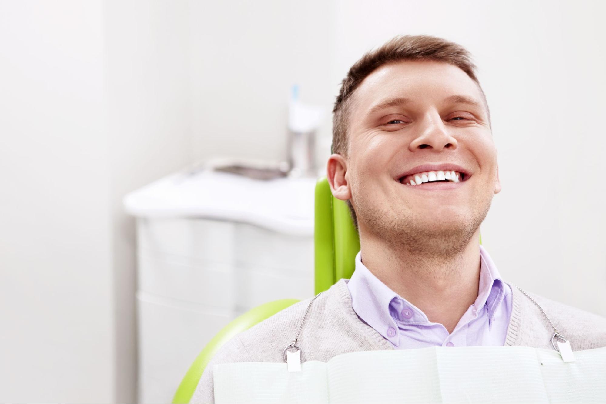 Man smiling in a dental exam chair. 