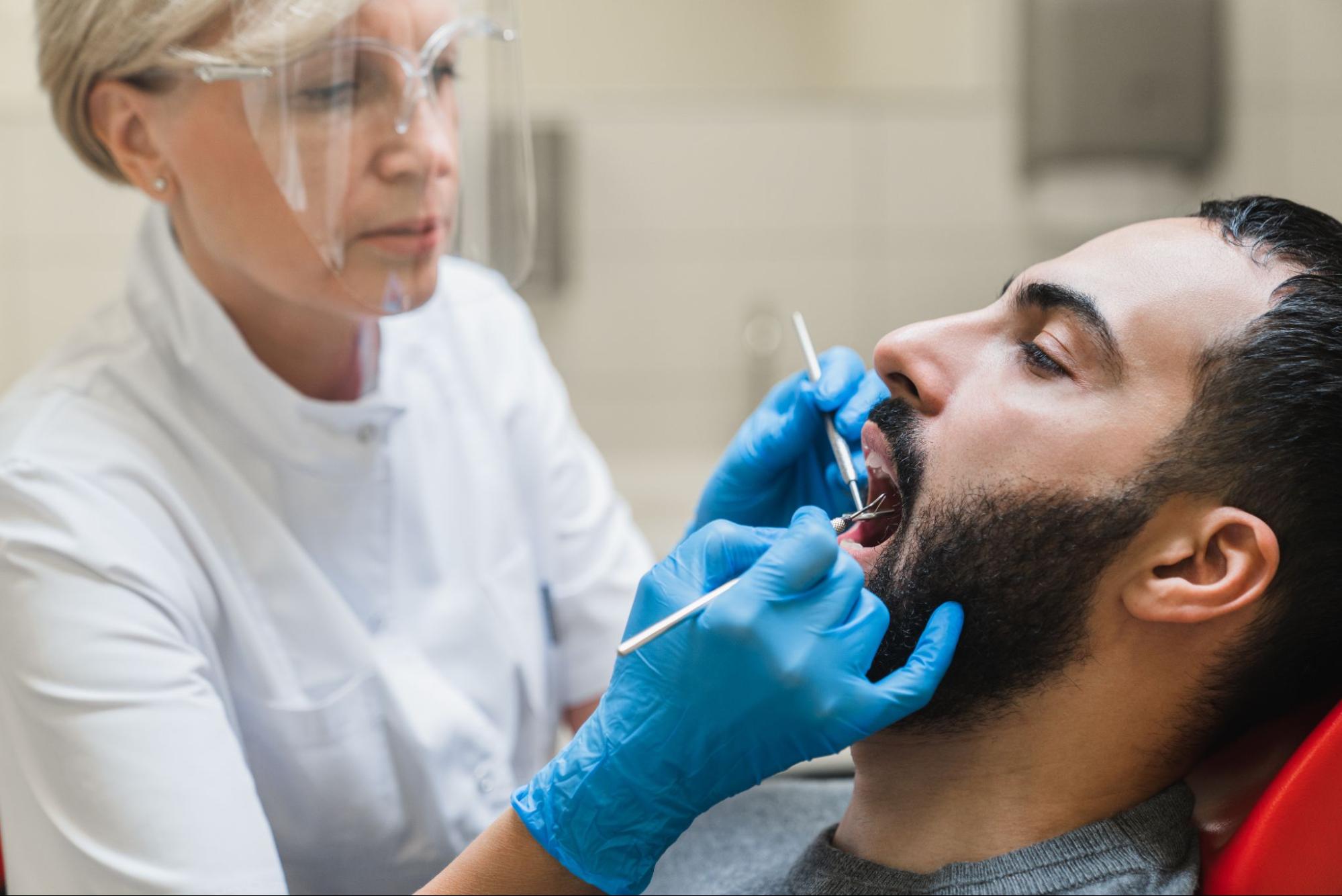 Female dentist performing a dental procedure on a patient in a clinic.