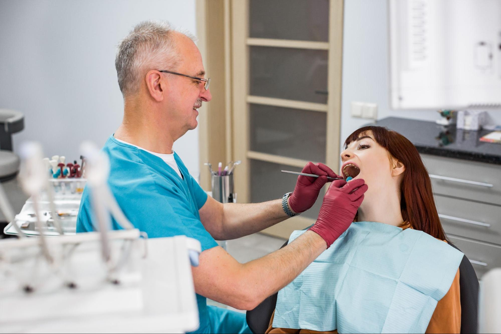A woman undergoes an oral check-up with her trusted dentist before getting cosmetic dental treatment. 