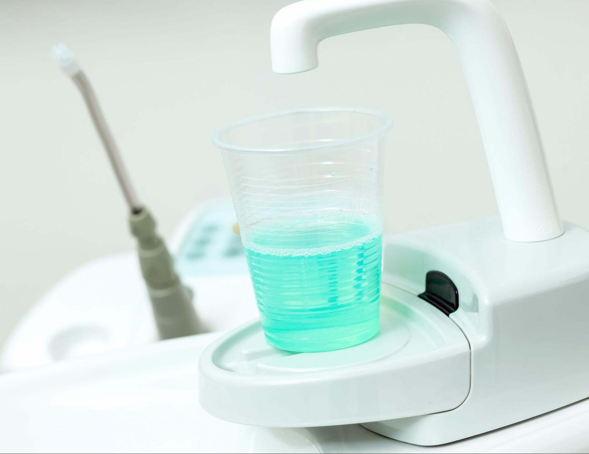 Fluoride mouth rinse in a dentist exam chair. 