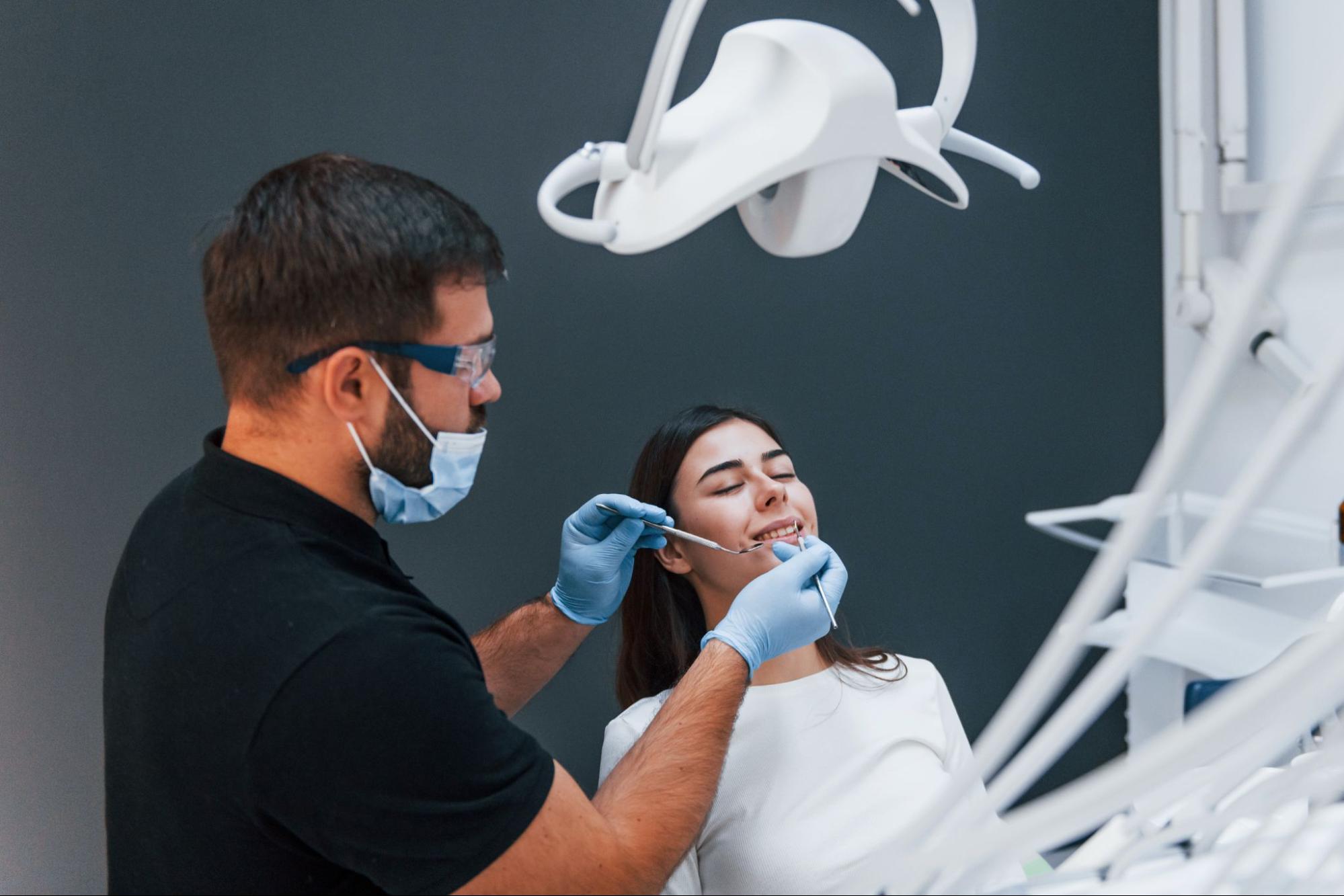 A young woman at a dental clinic consults with a dentist about gum contouring.