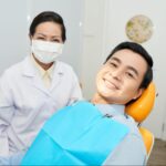 Patient next to a female dentist wearing a mask.