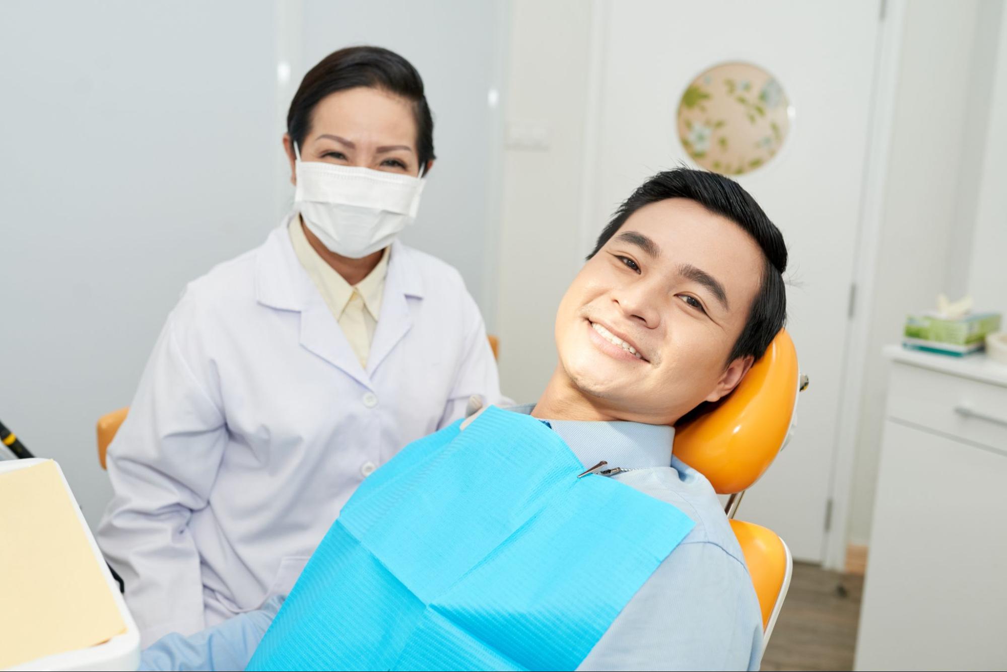 Patient next to a female dentist wearing a mask.