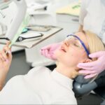 A woman looks at her restored tooth after receiving a dental crown.