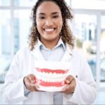 Happy dentist with a model of teeth.