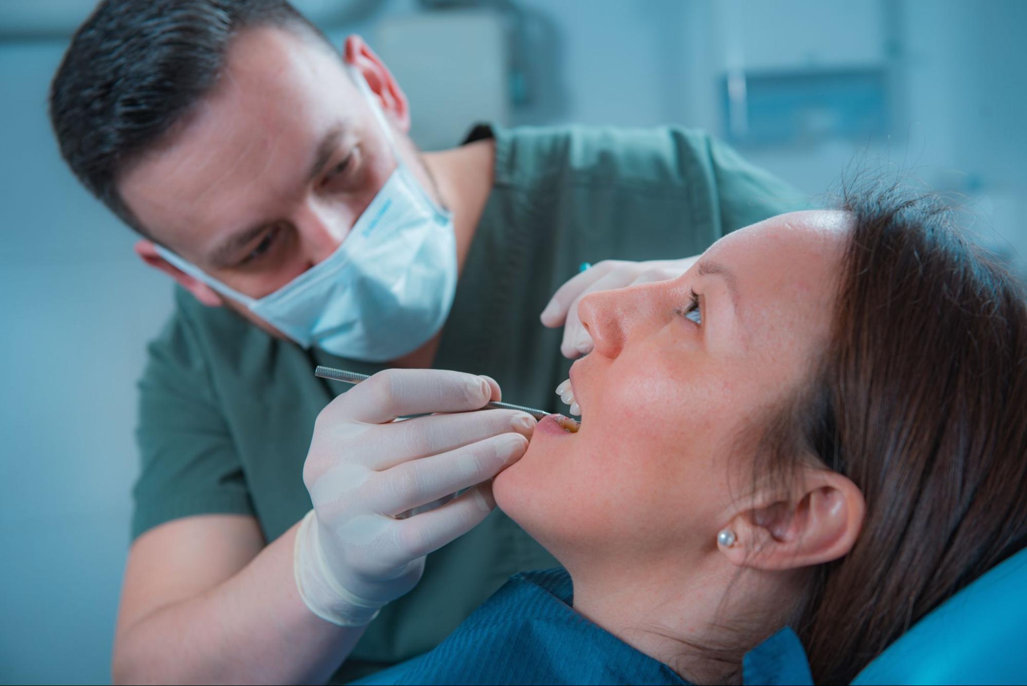 A patient undergoing a dental examination by a dentist.