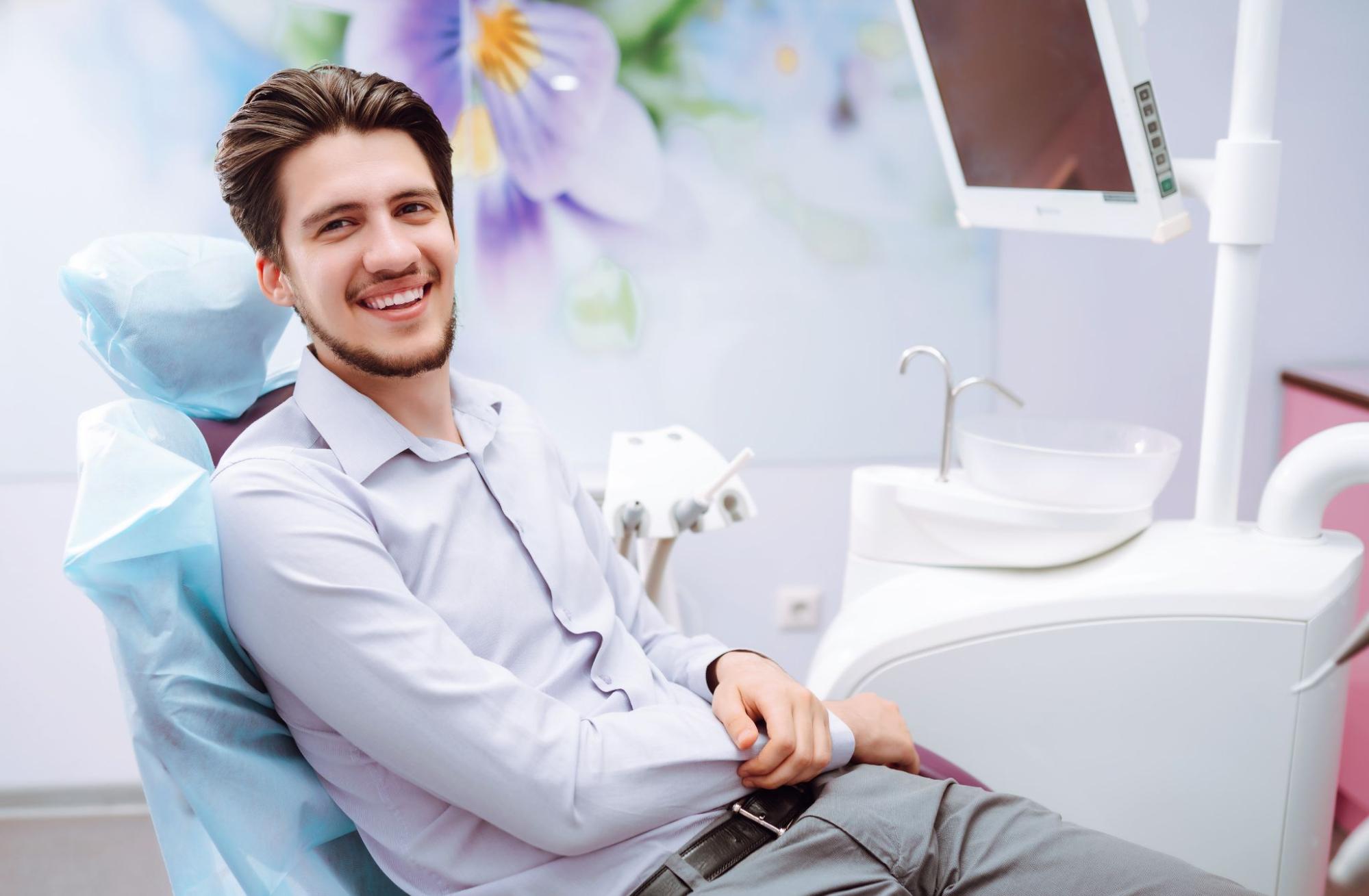 Man smiling in a dental exam chair. 